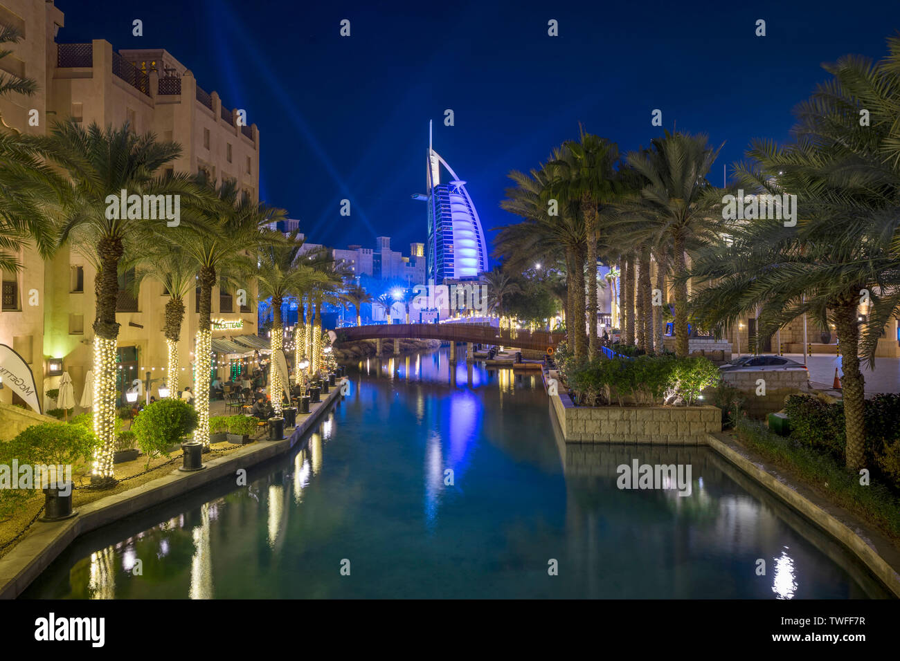 The Burj al Arab is illuminated in beams of light in Souk Madinat Jumeirah. Stock Photo