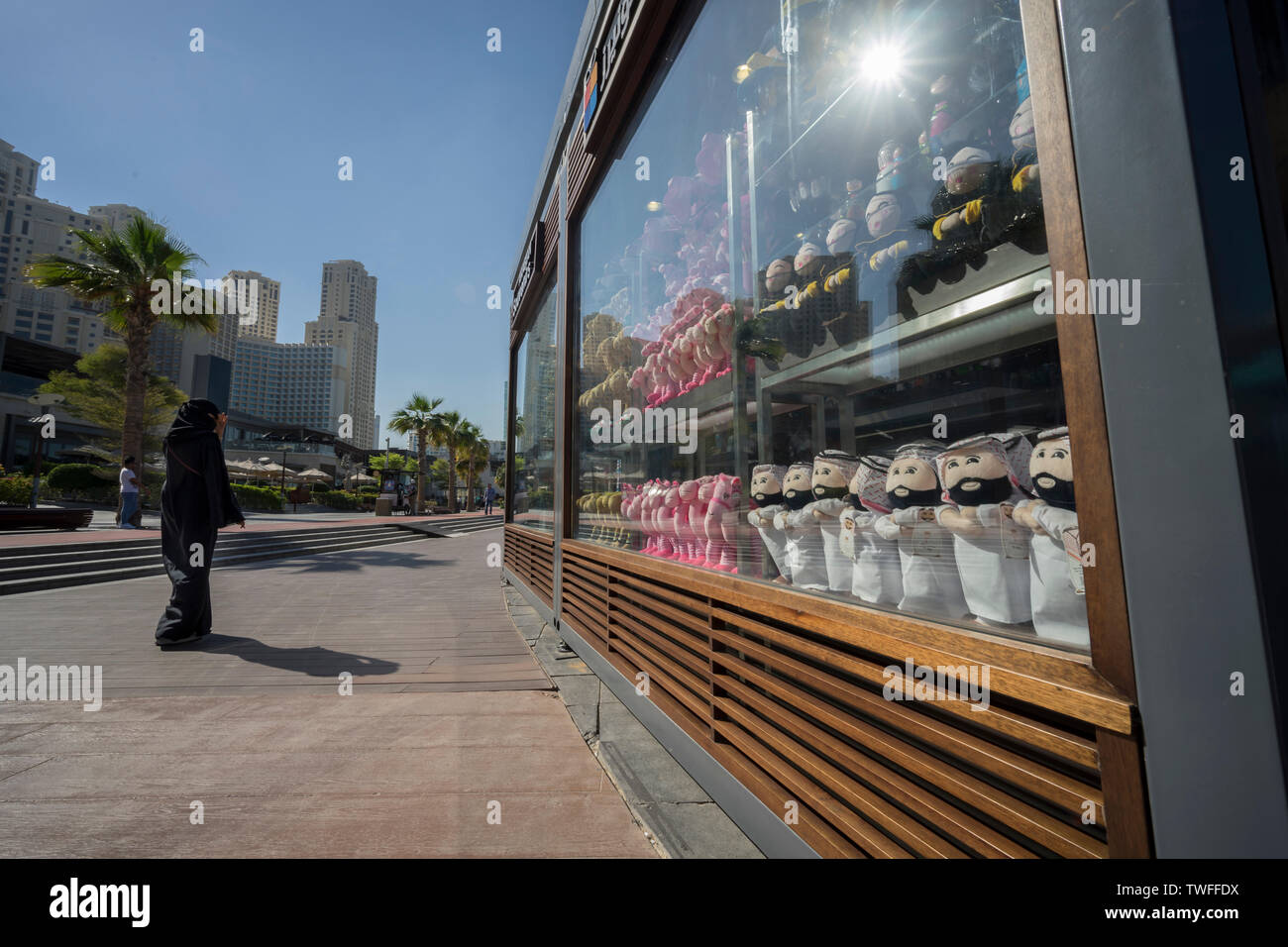 A woman walks past a shop window filled with Arabic souvenirs in Dubai. Stock Photo