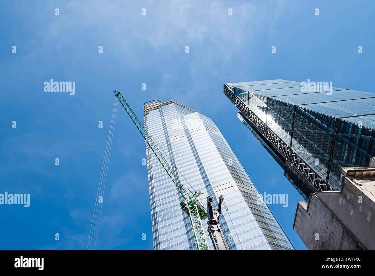 London, UK - May 14, 2019: Low angle view of skyscraper with cranes under construction in the City of London against blue sky with space for copy Stock Photo