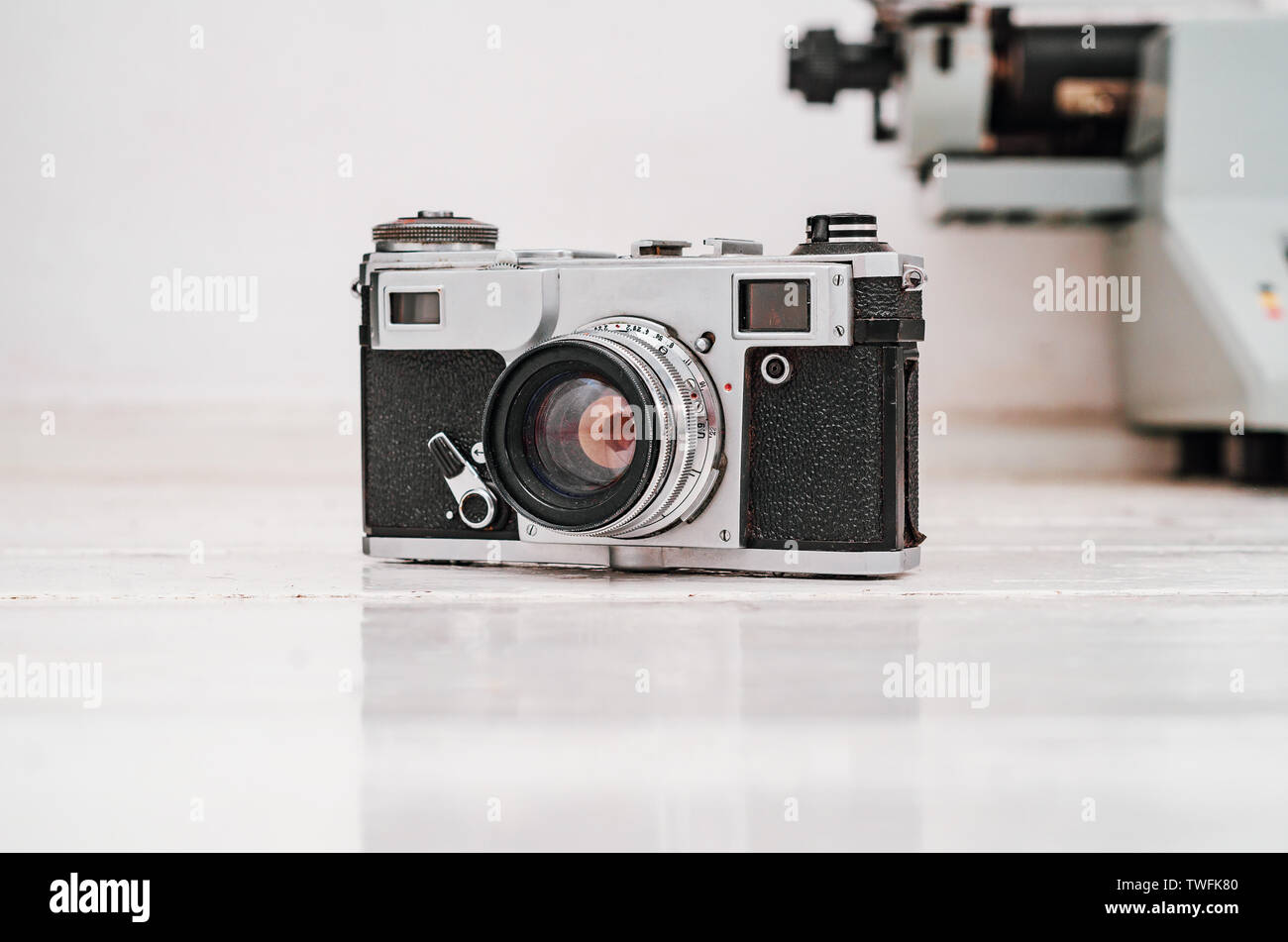 Old film camera on white plank background. Typewriter on the background. Vintage photo. Stock Photo