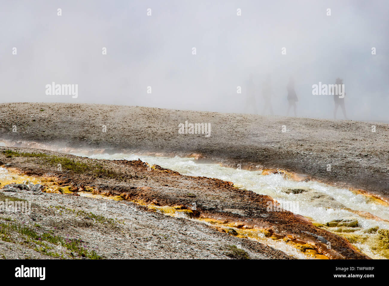 Water running off Excelsior geyser crater into the Firehole river Stock Photo