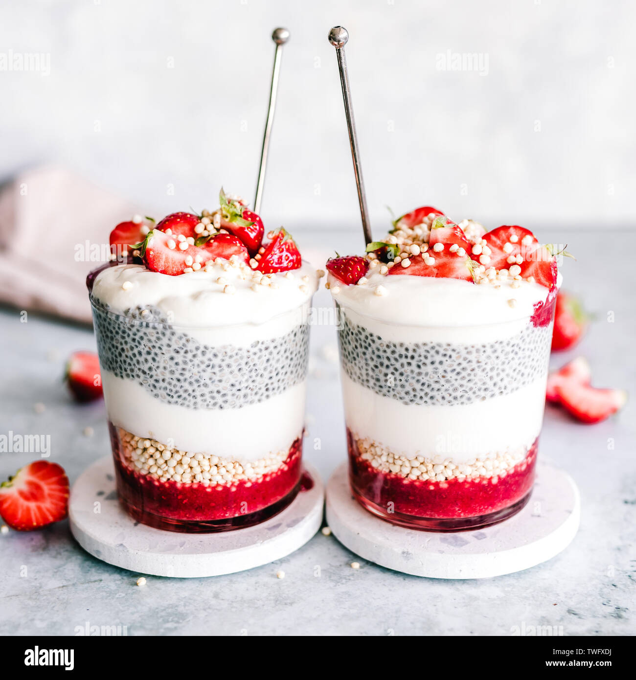 Two Chia pudding cups with coconut yogurt, strawberry and puffed quinoa Stock Photo