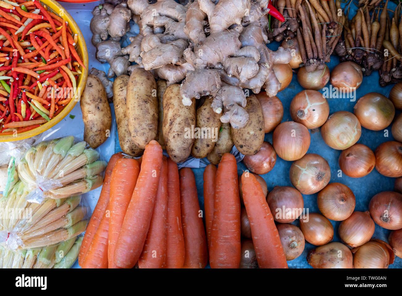 Overhead view of onion, carrot, potato, ginger and chili in a market, Thailand Stock Photo
