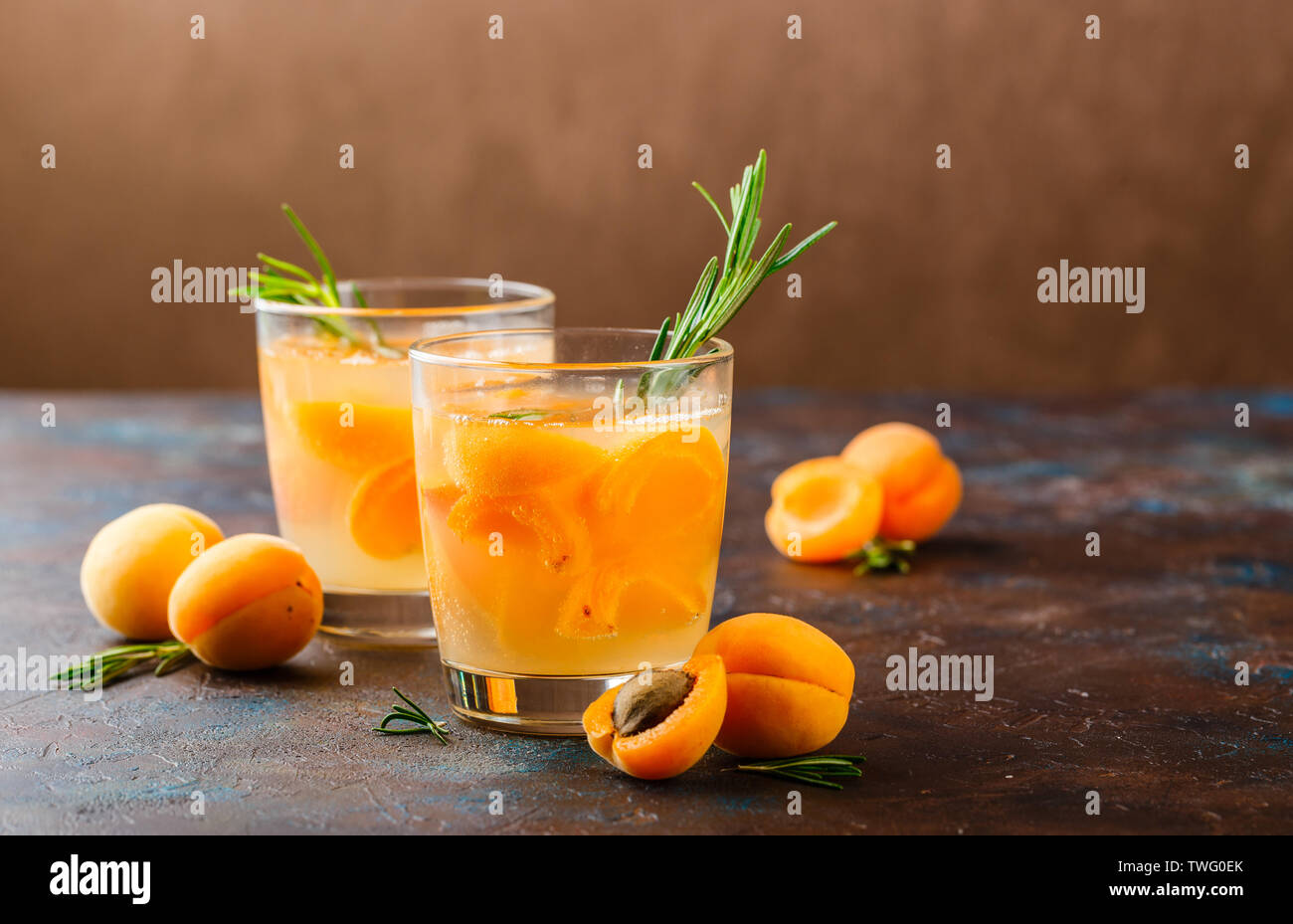 Summer drinks, rosemary aprcot cocktails with ice in glasses. Refreshing summer homemade Alcoholic or non-alcoholic cocktailsor Detox infused flavored Stock Photo