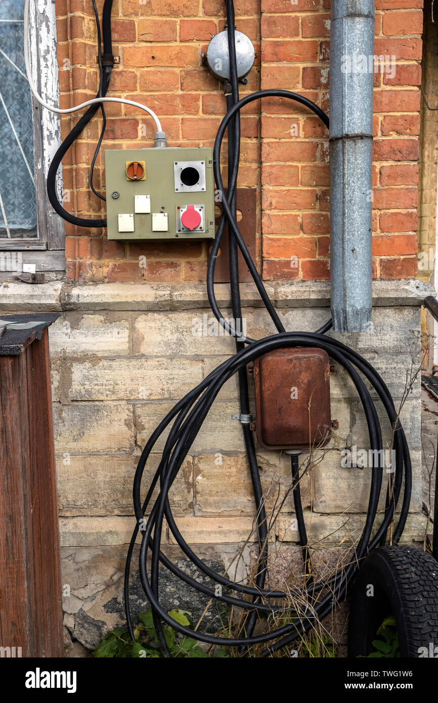 wires and cables as well as old electronic panels attached to the house