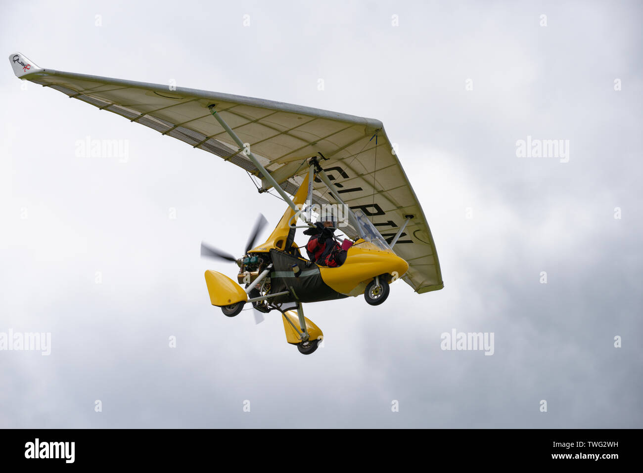 Smart looking yellow QuikR flex wing microlight aircraft flying above Popham Airfield near Basingstoke Hampshire Stock Photo