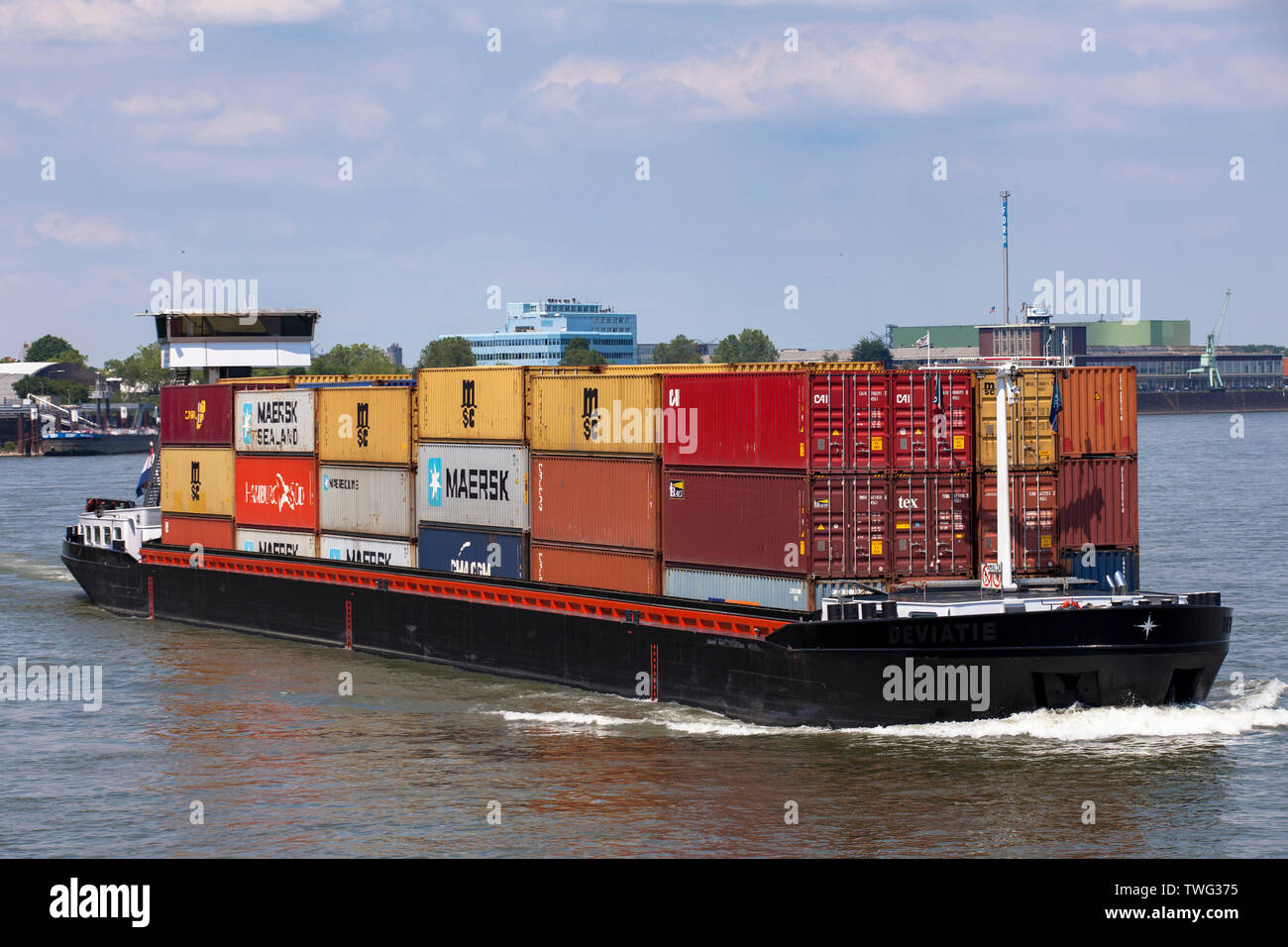 a container ship on the river Rhine  in the town district Niehl, Cologne, Germany.  ein Containerschiff auf dem Rhein im Stadtteil Niehl, Koeln, Deuts Stock Photo