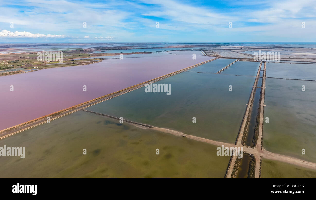 Square lagoons for evaporation of salt and a pond with red water. Aerial view. Stock Photo