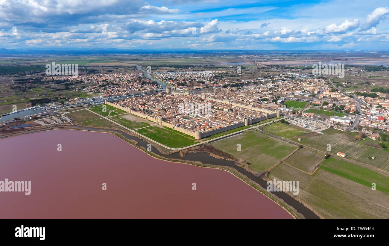 Medieval town fortress on the shore of the pink lake in France. Aerial view. Stock Photo