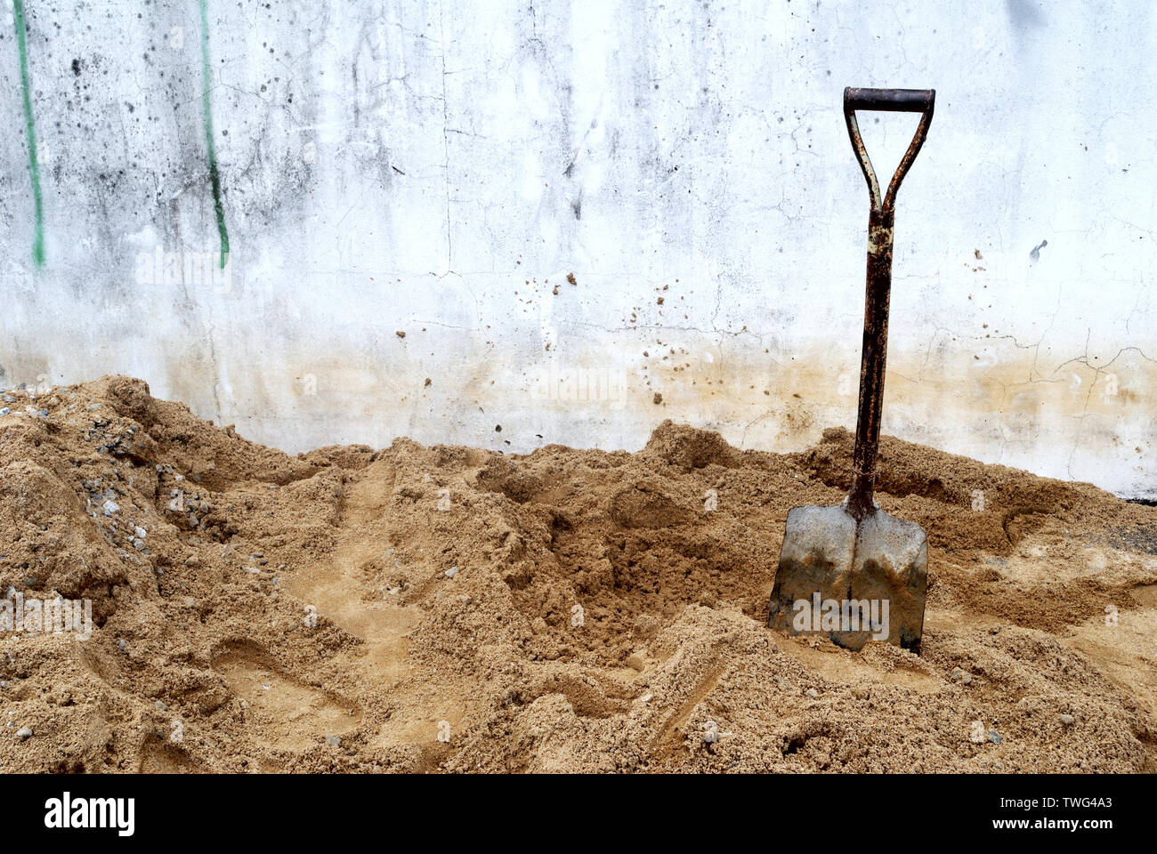 The shovels that are placed on the sand pile are used to scoop the sand