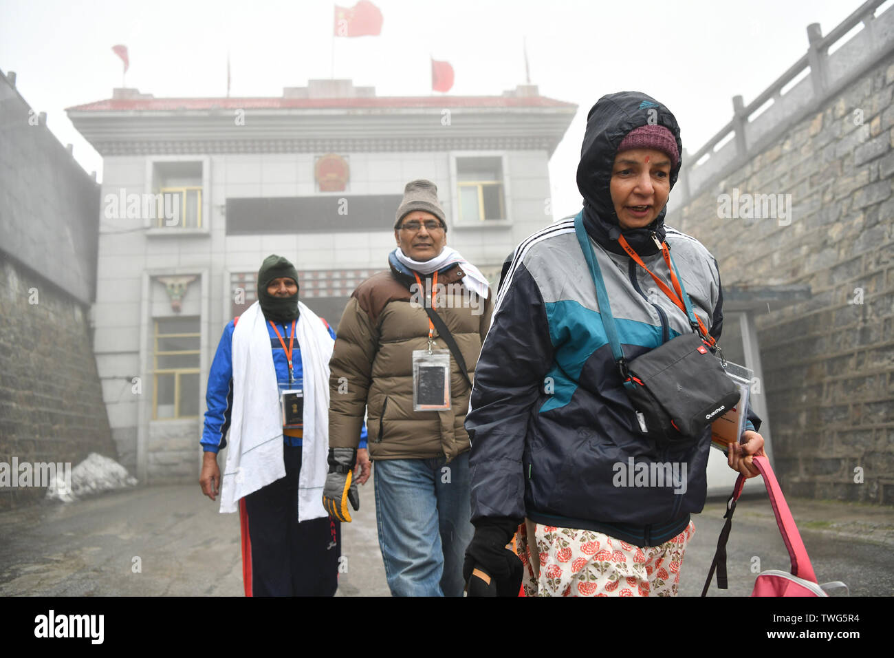 Yadong, China's Tibet Autonomous Region. 20th June, 2019. A group of Indian pilgrims enter China from Nathu La Pass in Yadong County, southwest China's Tibet Autonomous Region, June 20, 2019. The first group of officially organised pilgrims from India this year arrived at Nathu La Pass along the China-India border on Thursday. The 36 members on the pilgrim group will travel to Ali Prefecture for a 12-day pilgrimage around Mount Kangrinboqe and Mapam Yumco Lake, both sacred Hindu and Buddhist sites. Credit: Li Xin/Xinhua/Alamy Live News Stock Photo