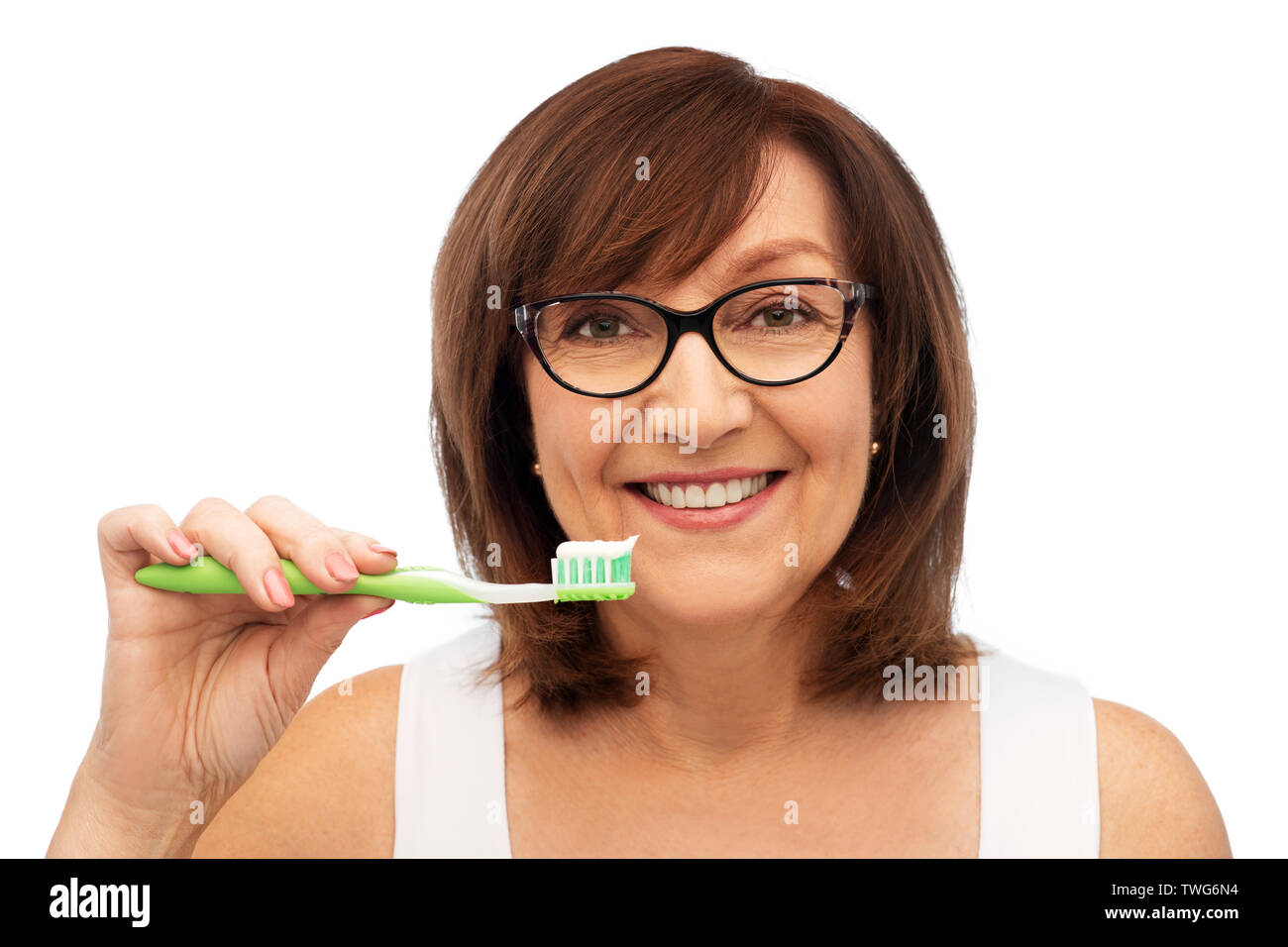 senior woman with toothbrush brushing her teeth Stock Photo