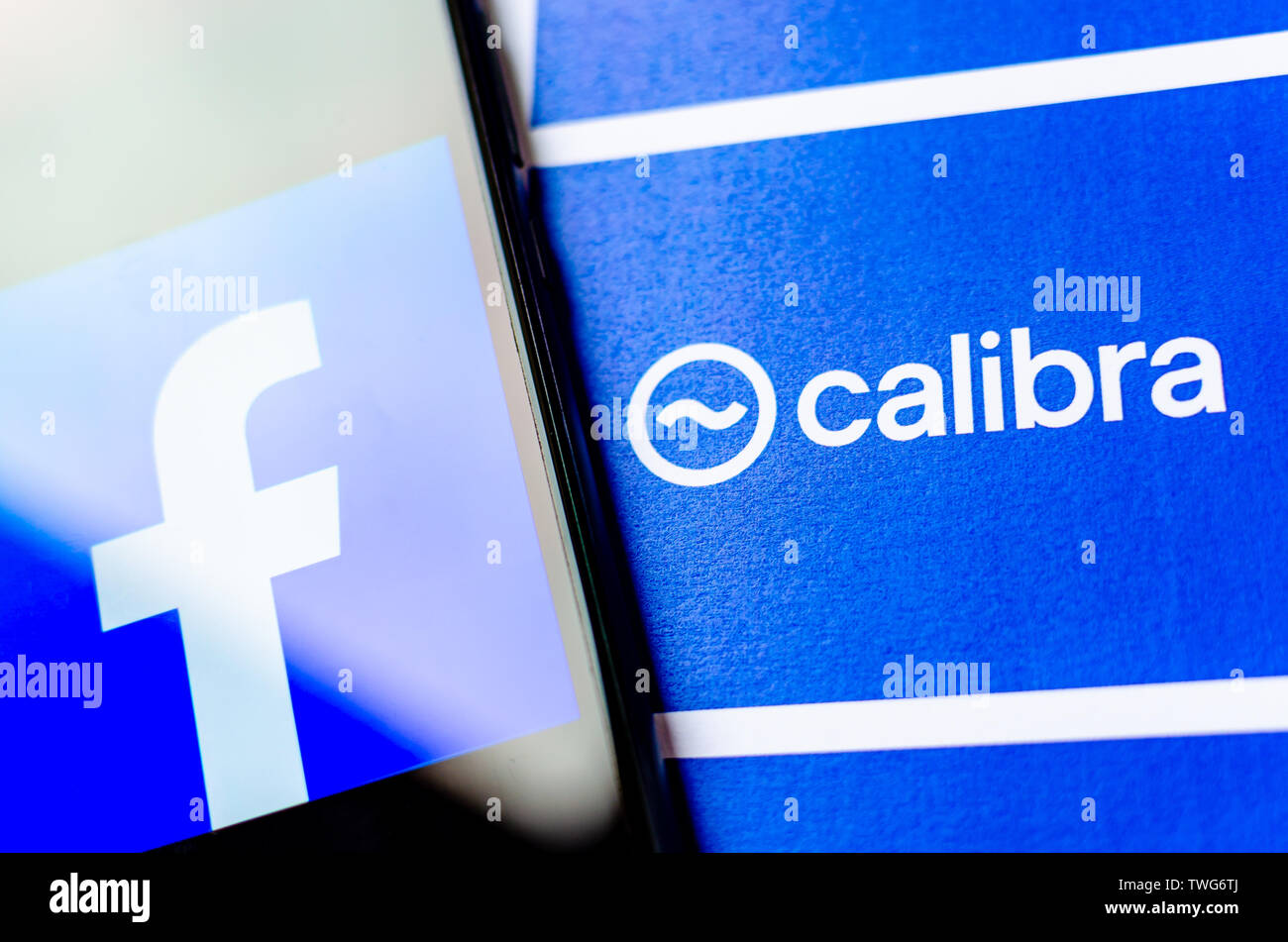 Facebook Calibra - new digital wallet for crypto coin Libra. Photo of smartphone with FB logo next to broshure with Calibra logo. Stock Photo