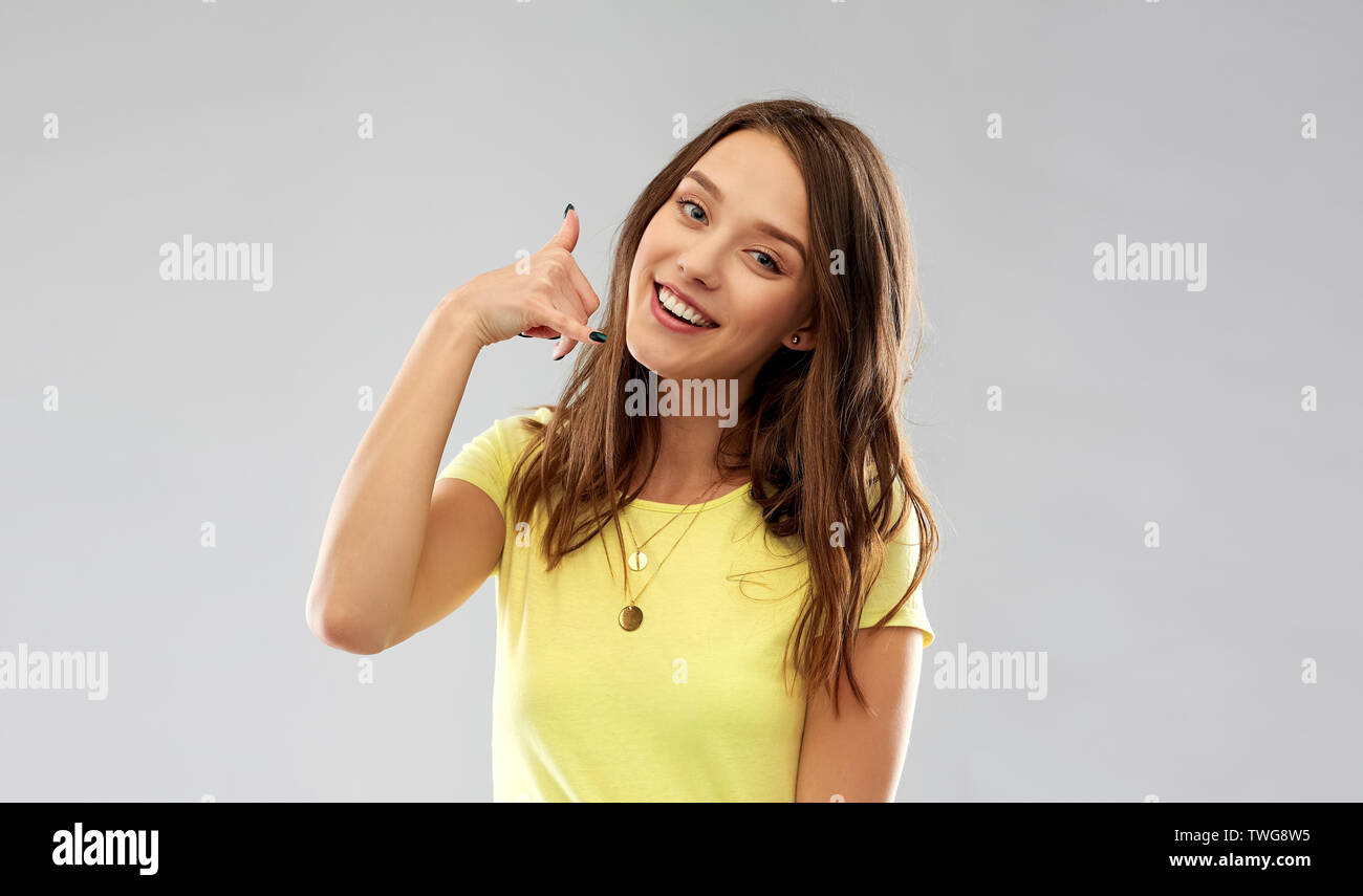 young woman or teenage girl showing call gesture Stock Photo