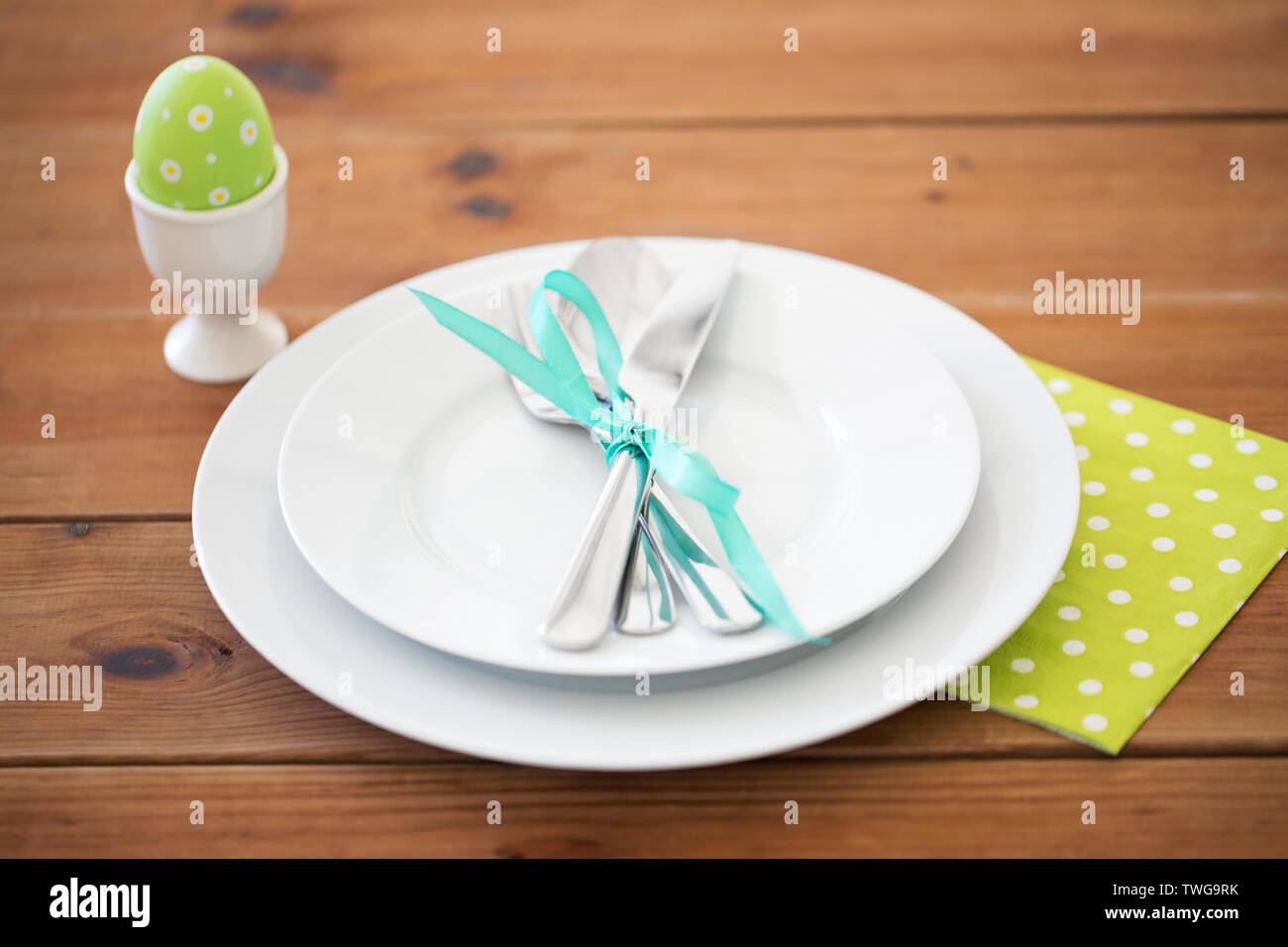easter egg in cup holder, plates and cutlery Stock Photo Alamy