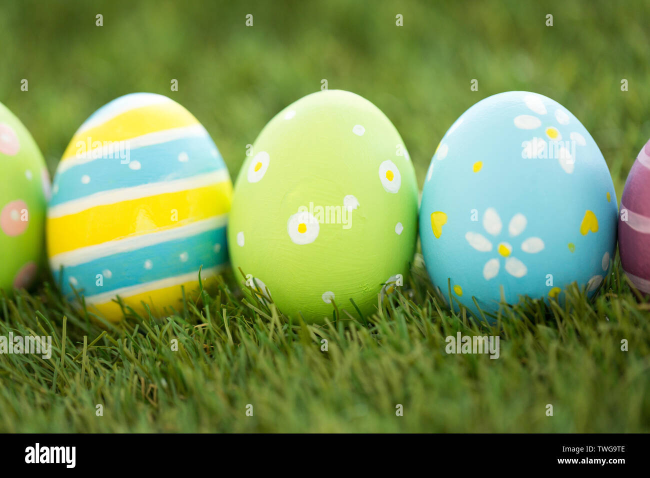 row of colored easter eggs on artificial grass Stock Photo