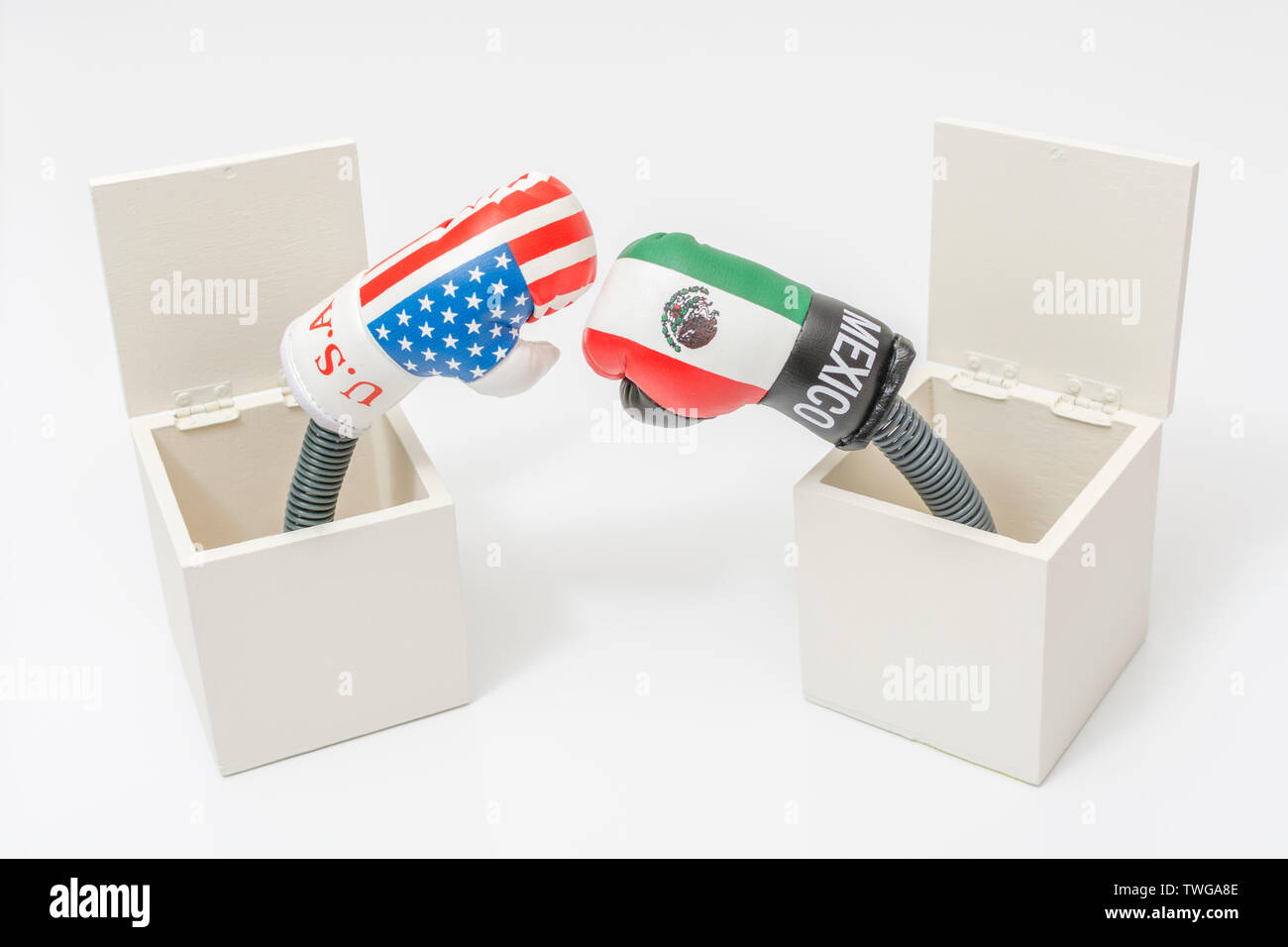 Mini U.S. & Mexico boxing gloves in Jack in a Box concept. Metaphor U.S. Mexico relations, U.S. Mexico trade war, U.S Mexico tariffs, US trading blows Stock Photo