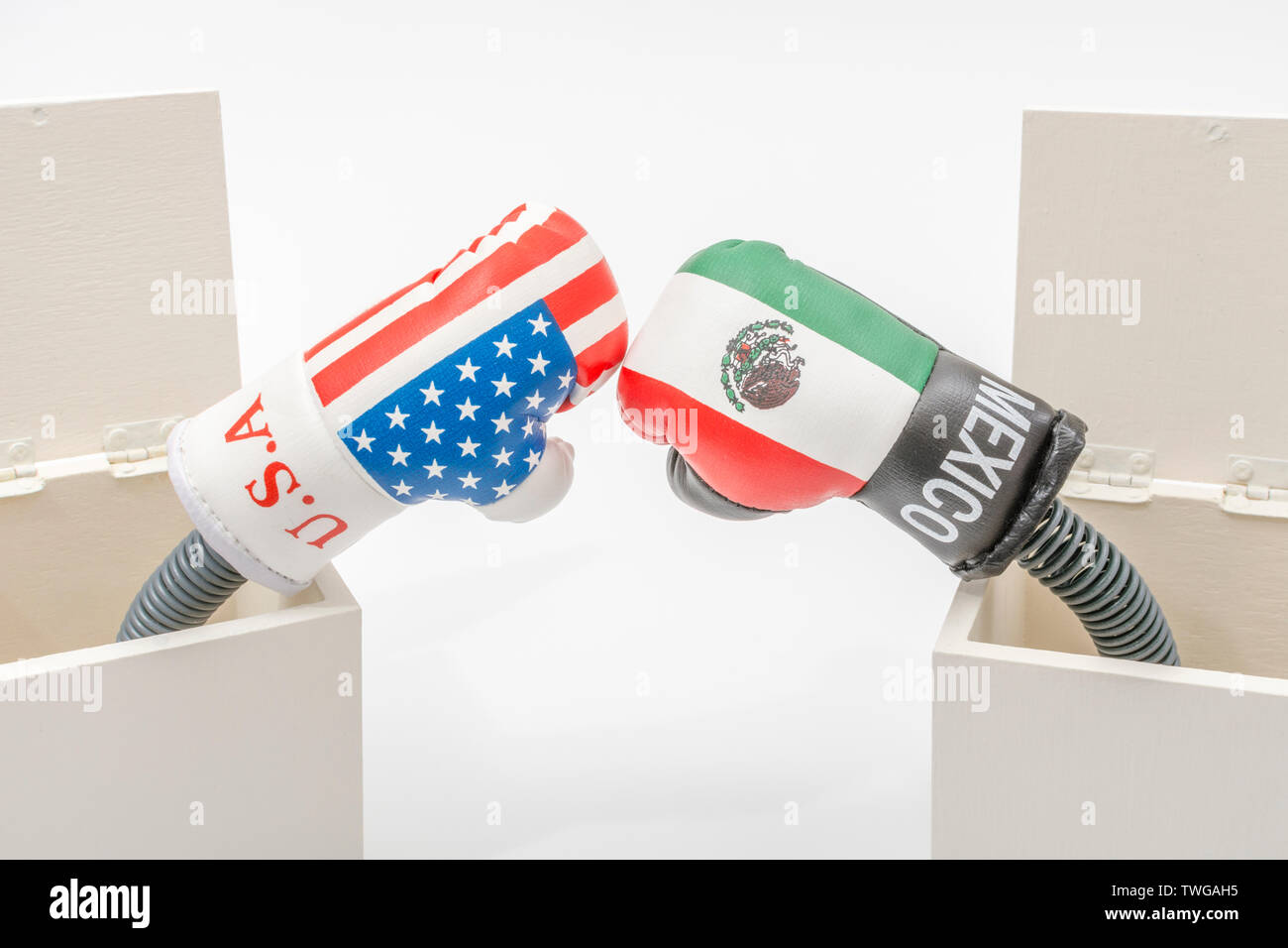 Mini U.S. & Mexico boxing gloves in Jack in a Box concept. Metaphor U.S. Mexico relations, U.S. Mexico trade war, U.S Mexico tariffs, US trading blows Stock Photo
