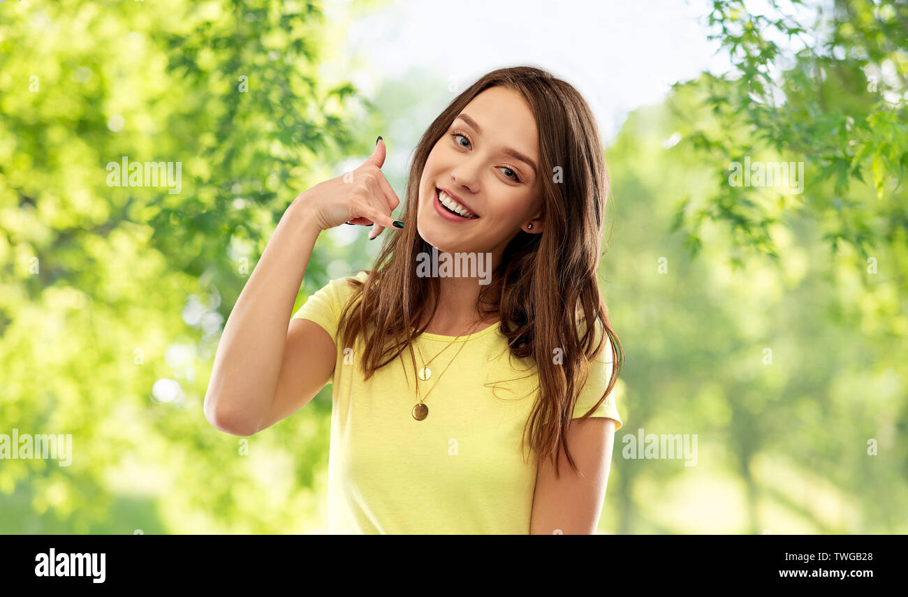 young woman or teenage girl showing call gesture Stock Photo