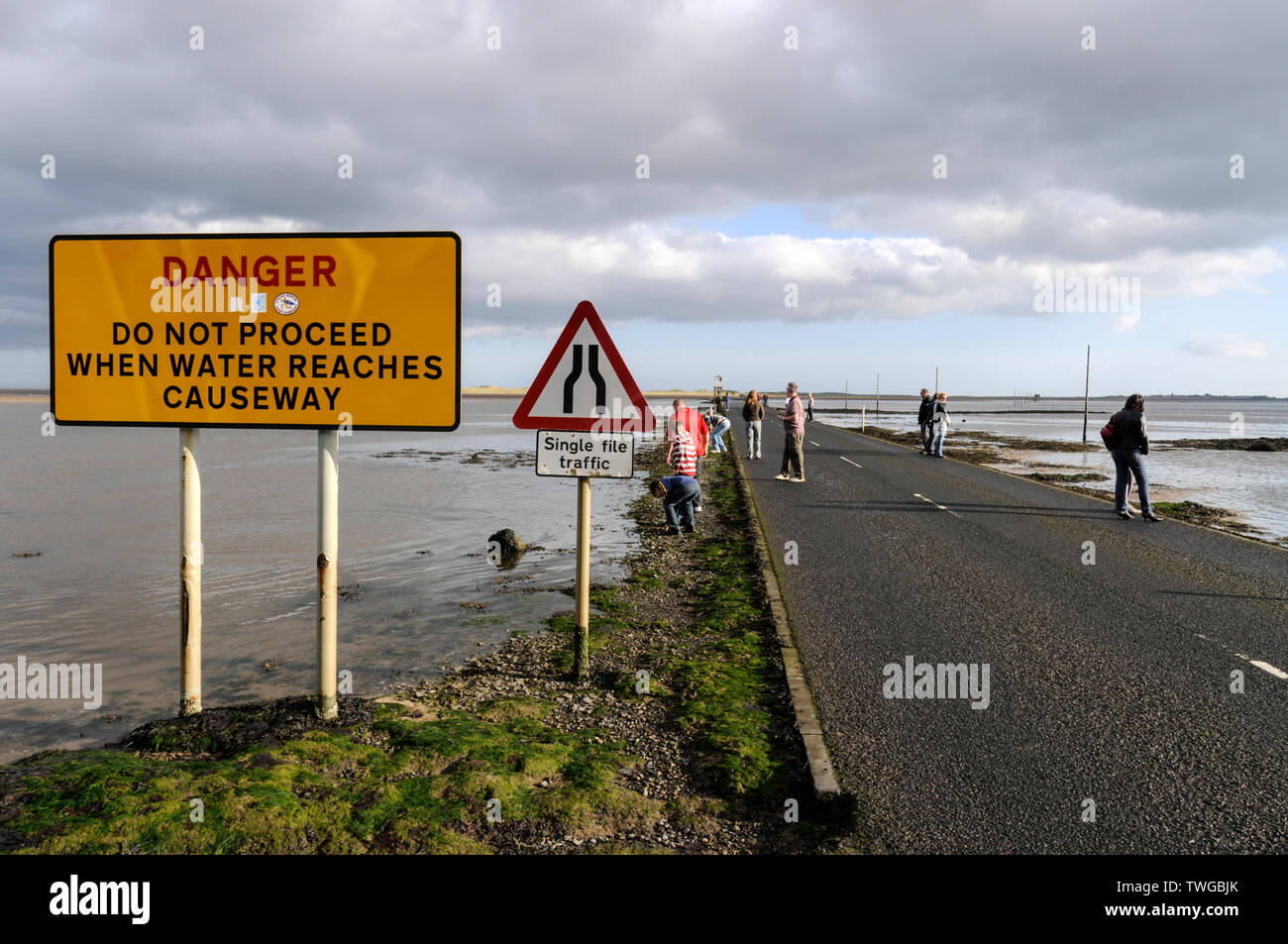 The 'Tide Times' warning notices before crossing the causeway to Holy Island in Northumberland, Britain The small tidal island is only accessible Stock Photo