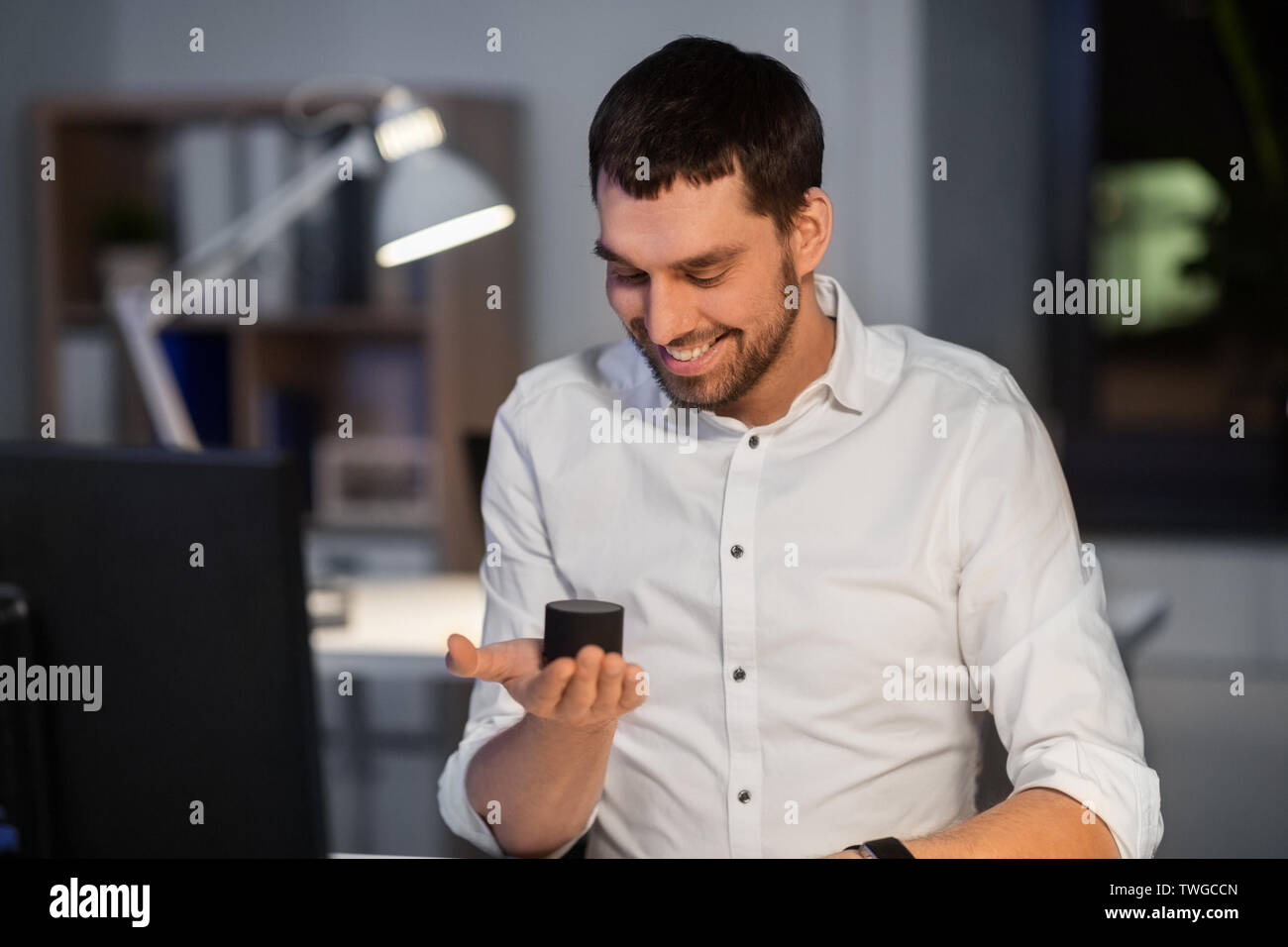 businessman using smart speaker at night office Stock Photo