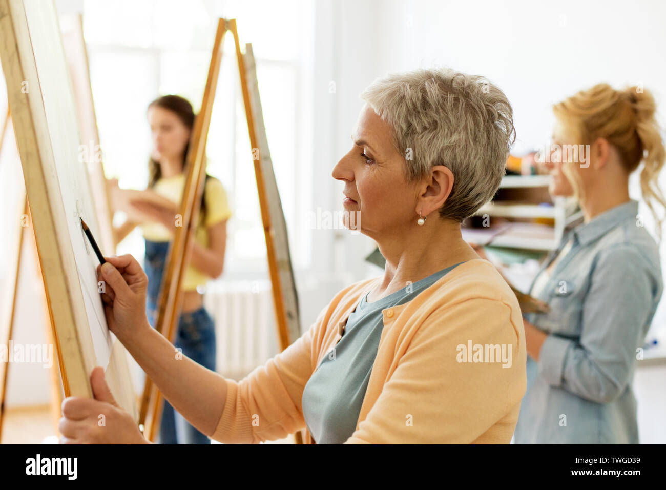 senior woman drawing on easel at art school studio Stock Photo - Alamy