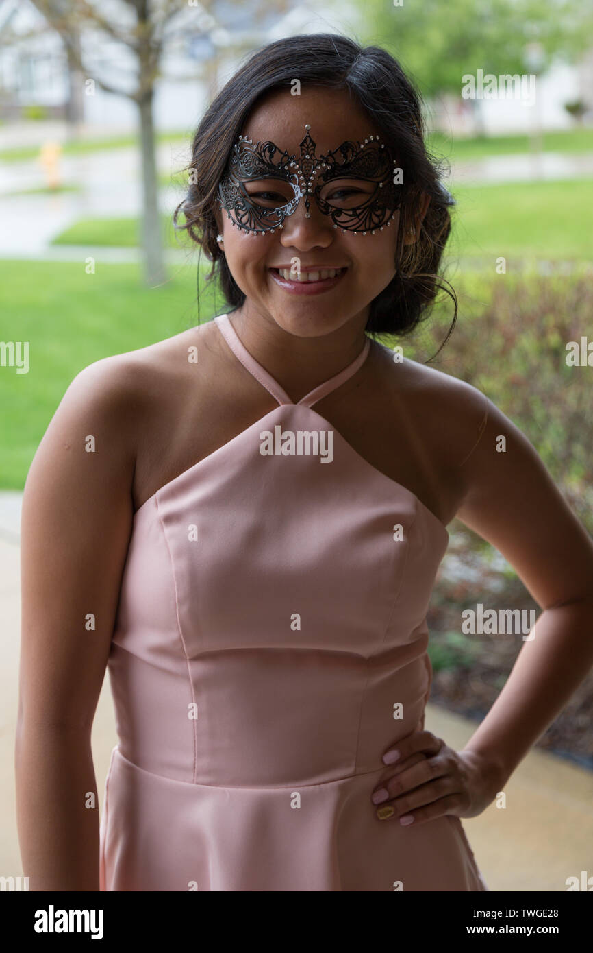 A beautiful teenage girl poses for the camera while attending a masquerade ball at the Fort Wayne Country Club in Fort Wayne, Indiana, USA. Stock Photo