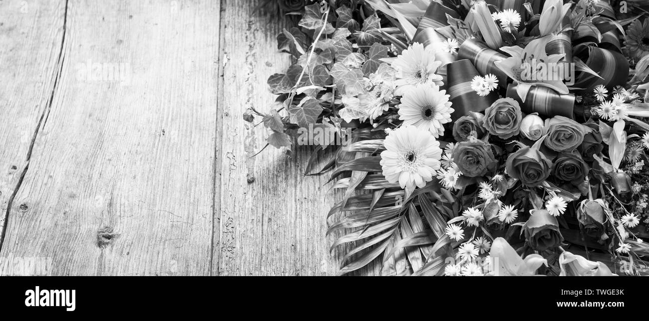 Floral wreath on weathered wooden background with copy space in stunning black and white Stock Photo