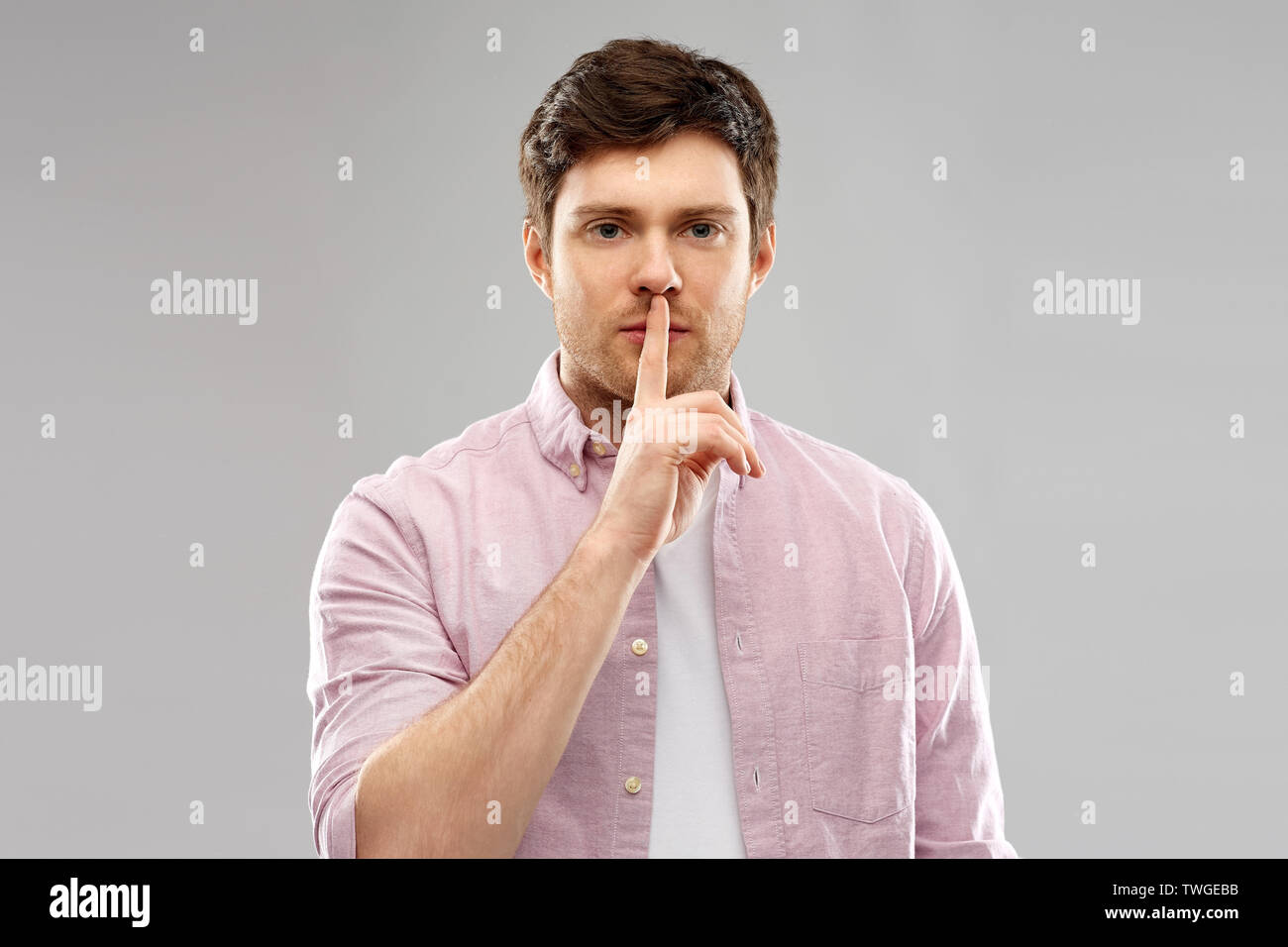 young man with finger on lips Stock Photo