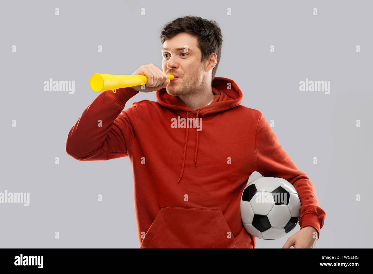 football fan with soccer ball blowing horn Stock Photo Alamy