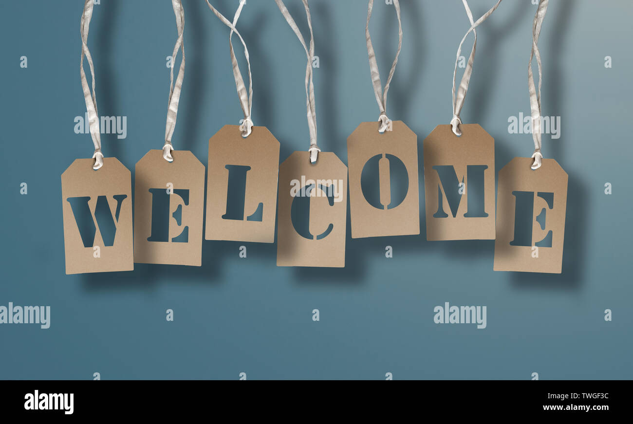 WELCOME on set of brown hang tags or cardboard labels against light blue background Stock Photo