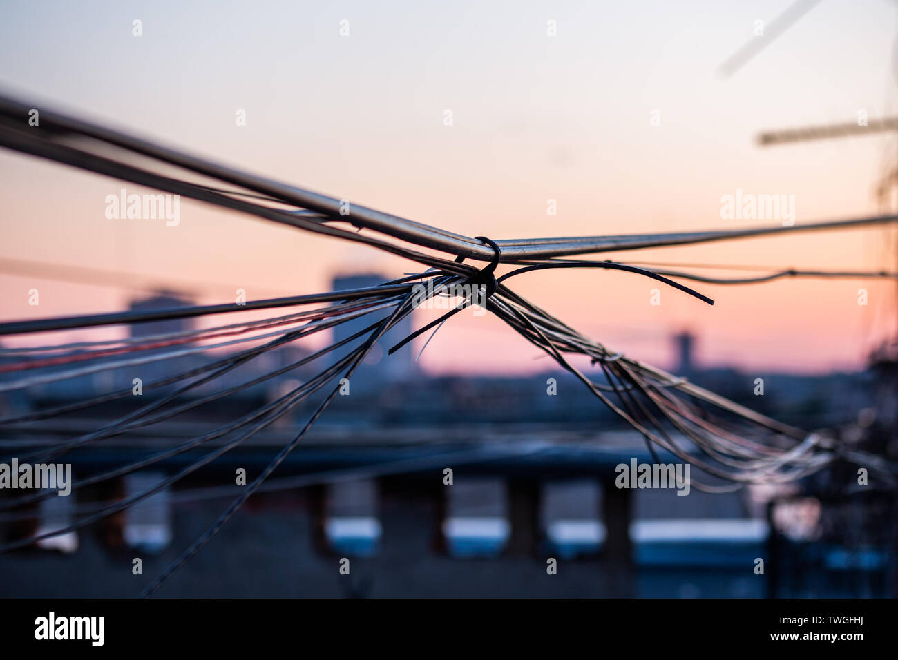 A wisp of wires on evening city roof with selective focus and boke blur Stock Photo