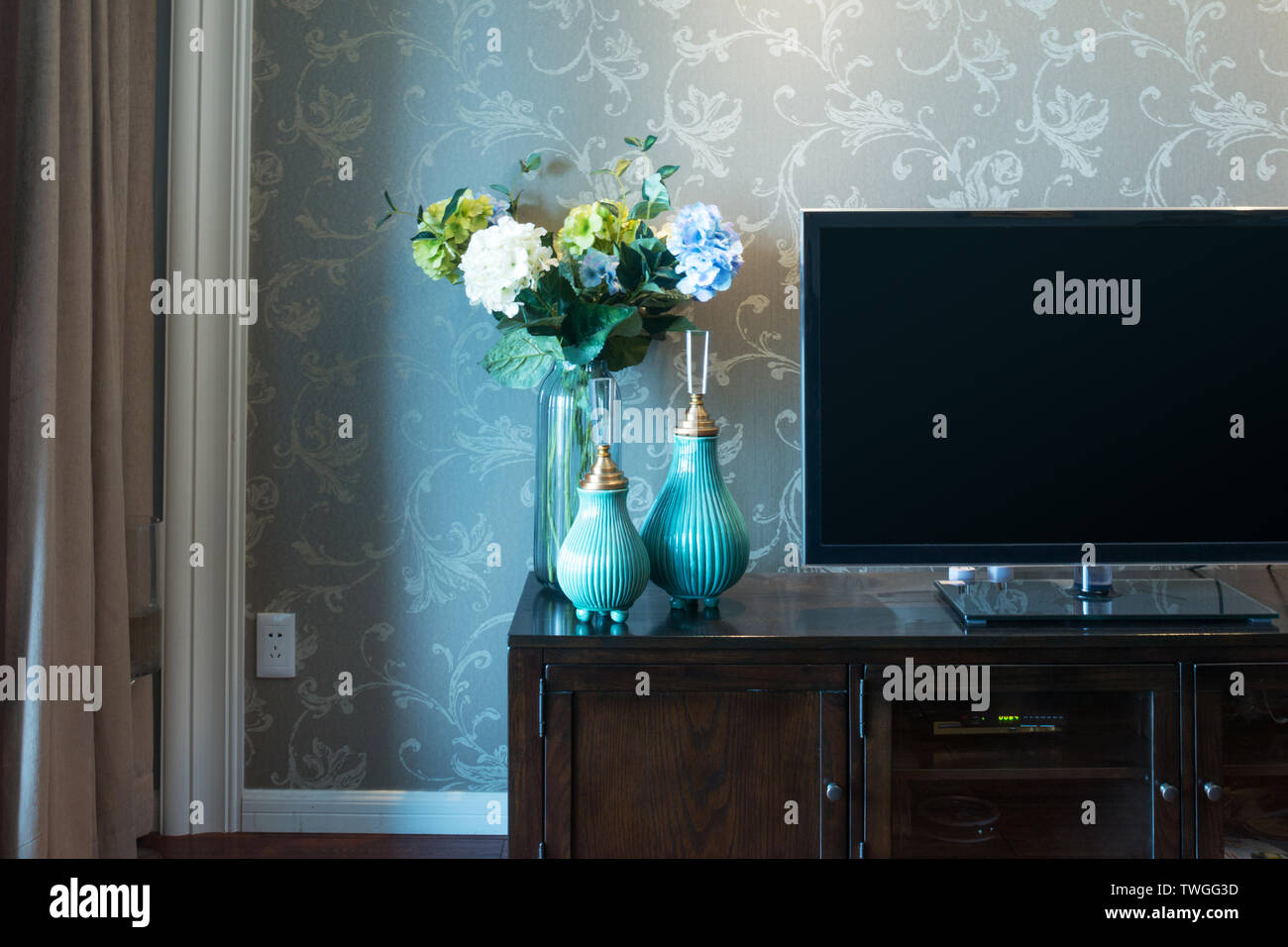 two elegant vases with flowers near TV in modern living room Stock Photo -  Alamy