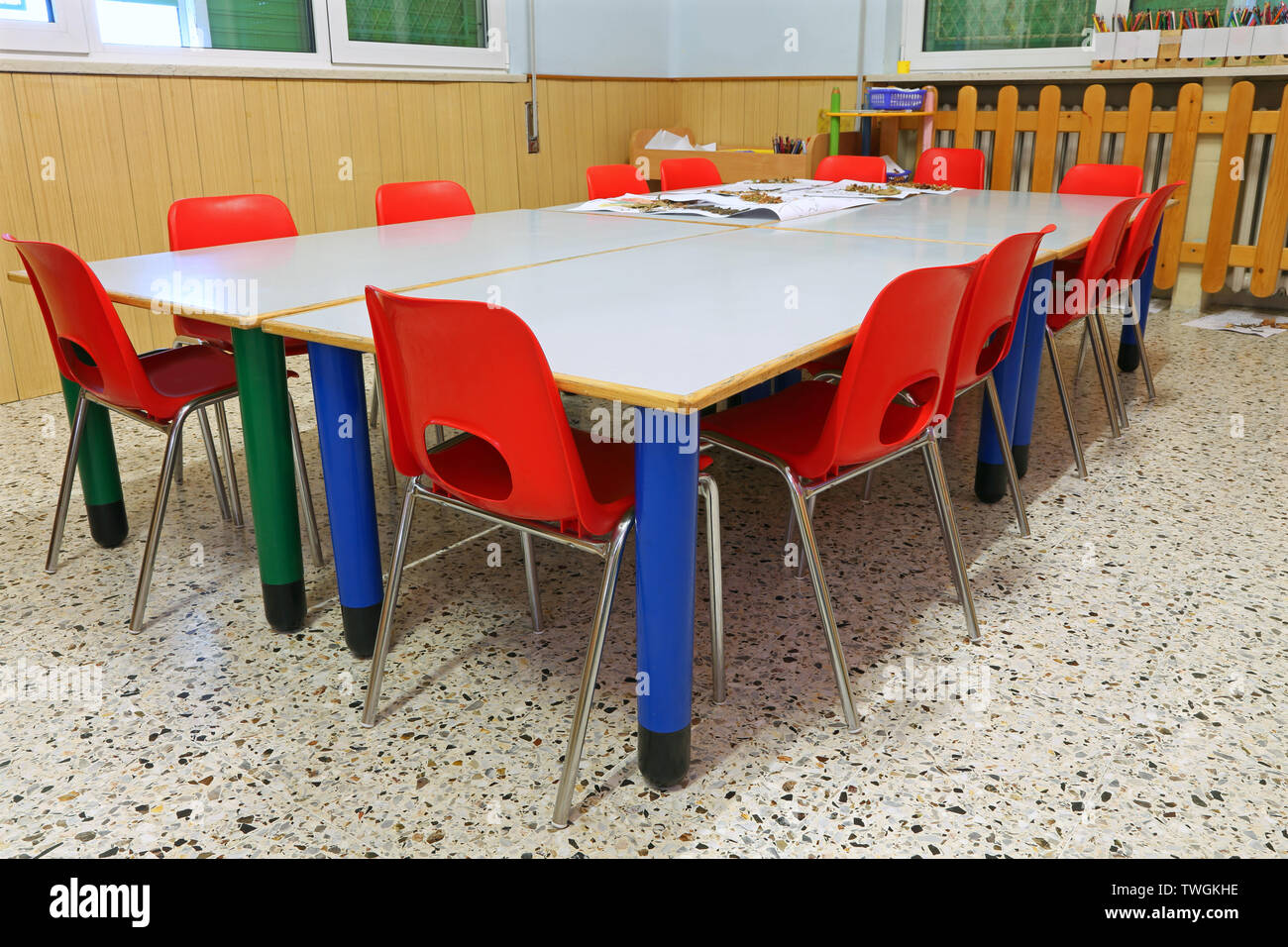 small red chairs and low tables inside a school classroom of the school without the kids Stock Photo