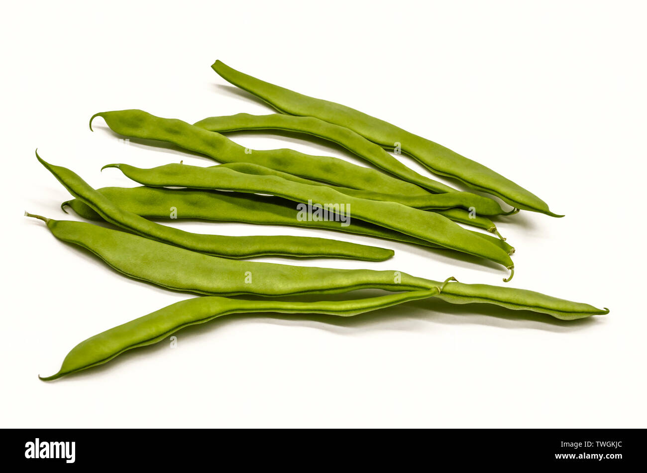Harvested unripe green bean pods for food use on a white background