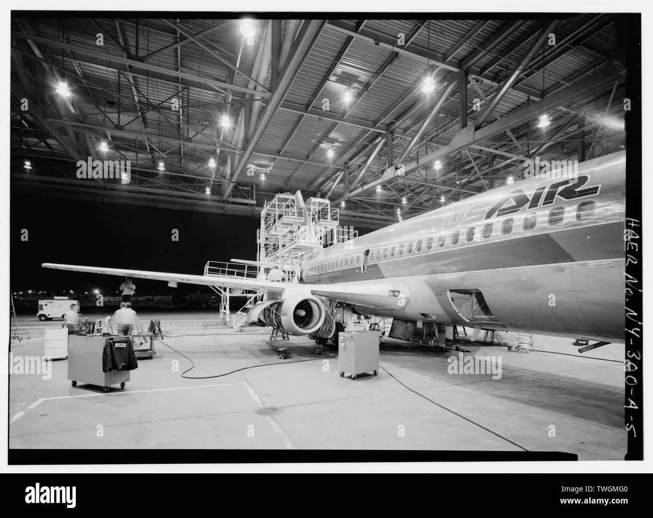 RIGHT ENGINE MAINTENANCE ON BOEING 737-200. THE COWLING OF THE RIGHT ENGINE IS OPEN, AND THE CREW IS WORKING ON THE JACK SCREWS THAT REGULATE THE FLAPS. MECHANICS WILL CHANGE ALL FUEL AND OIL FILTERS AS WELL AS CHECKING CHIP DETECTORS FOR METAL PARTICLES THAT INDICATE BEARING FAILURE. - Greater Buffalo International Airport, Maintenance Hangar, Buffalo, Erie County, NY Stock Photo