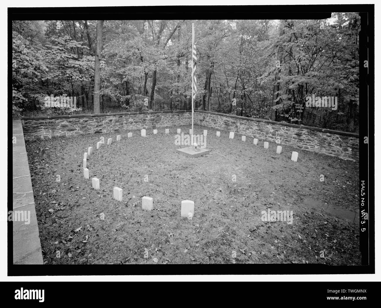 RING OF HEADSTONES INSIDE PERIMETER WALL, WITH FLAGPOLE AT CENTER. VIEW