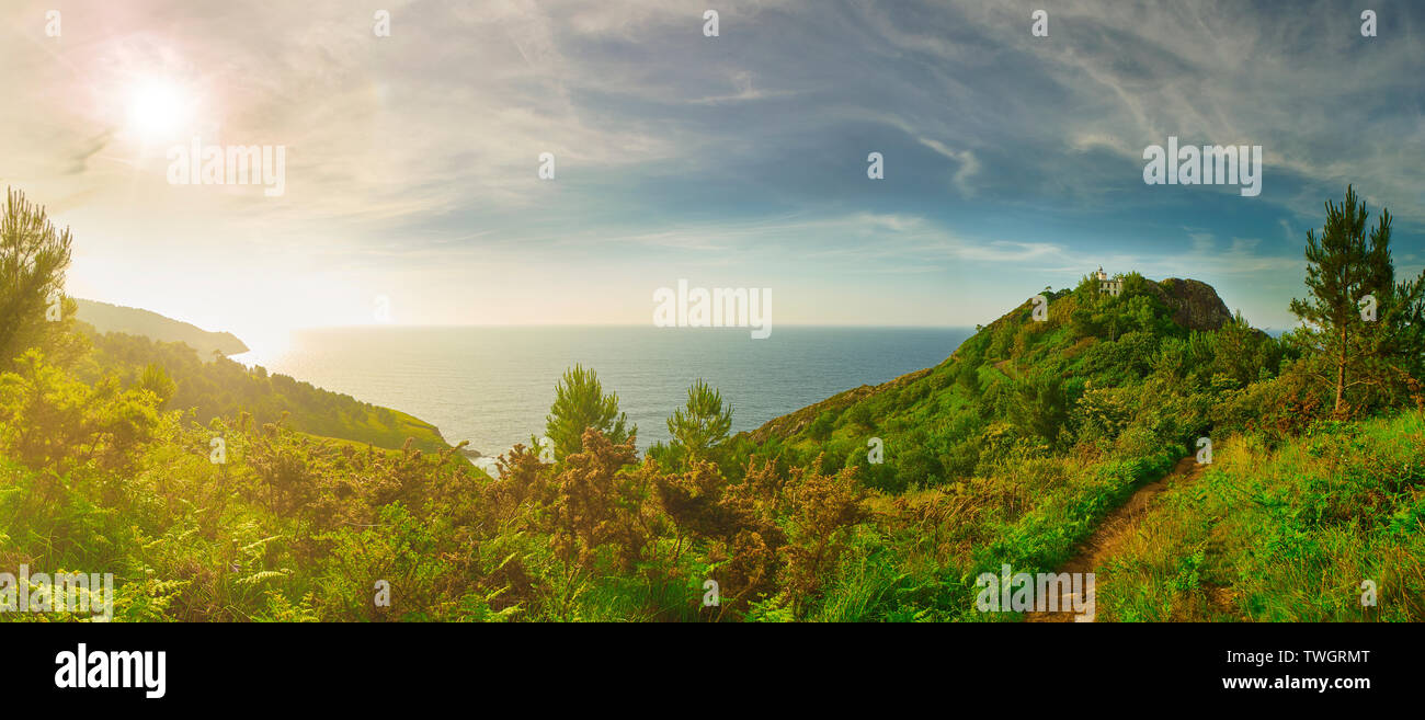 Panoramic view of Monte Ulia Mount at sunset with the Faro de la Plata (lighthouse) and the Cantabrian Sea in background. Pasaia, Gipuzkoa, Spain. Stock Photo