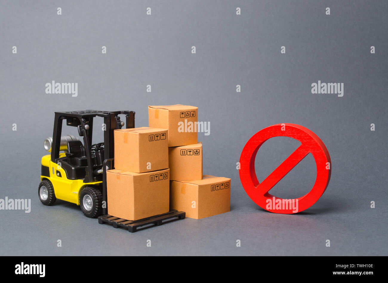 Forklift truck near cardboard boxes and a red symbol NO. Embargo, trade wars. Restriction on the importation of goods, proprietary for business. Inabi Stock Photo