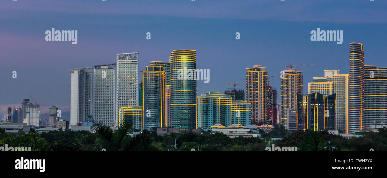 Skyscrapers in Bonifacio Global City (BGC) light up early evening in Metro Manila, Philippines, Stock Photo