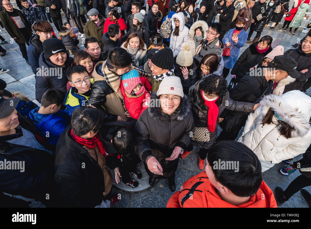 Tourists trying to step on the central point of Circular Mound Altar called Heart of Heaven in Temple of Heaven in Beijing, China Stock Photo