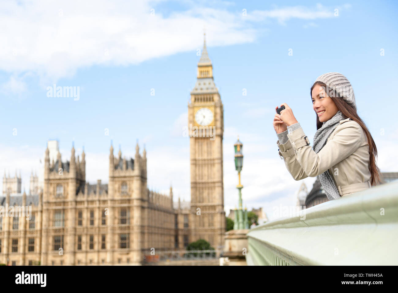 Travel tourist in london sightseeing taking photo pictures near Big Ben. Woman holding smart phone camera smiling happy near Palace of Westminster, Westminster Bridge, London, England Stock Photo