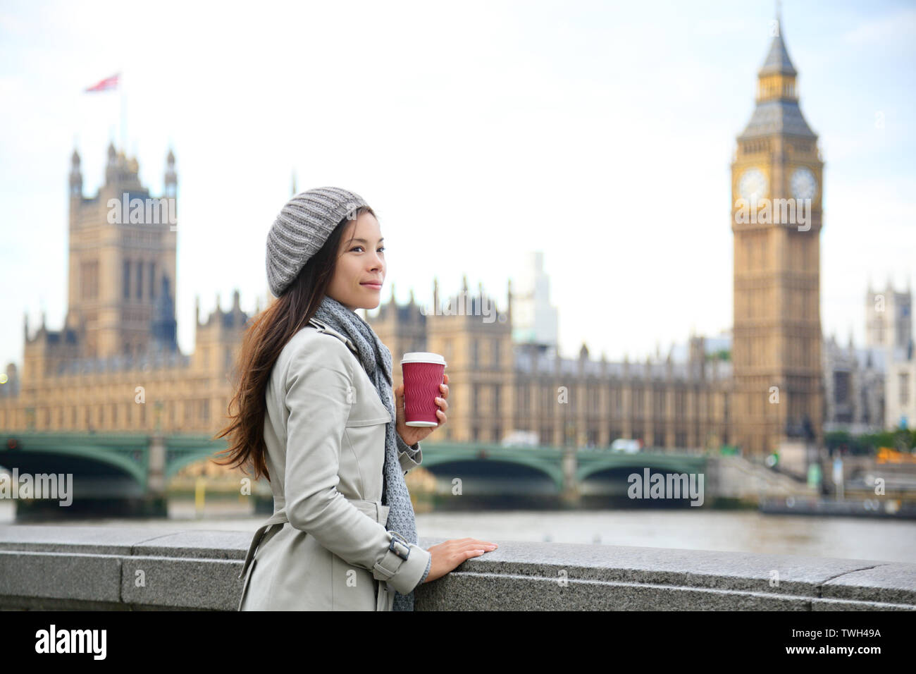 London woman drinking coffee by Westminster Bridge. Young female professional business woman in London, England. Beautiful young multiracial Asian Caucasian girl. Stock Photo