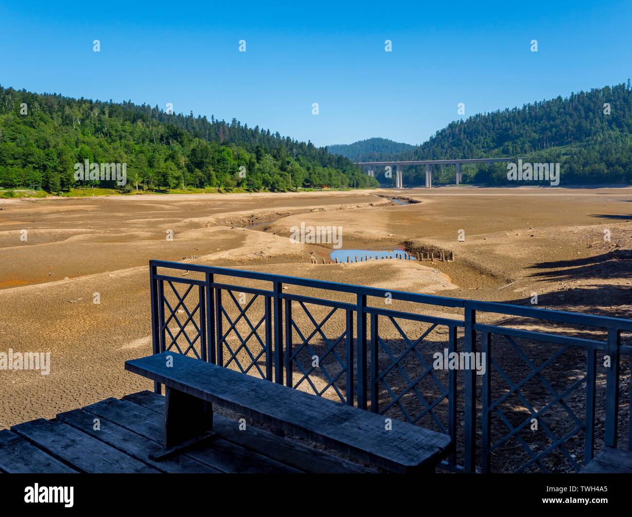Dried lake-bed Bajer in Fuzine Croatia Spring 2019 earth terrain with isolated small ponds metal fence in foreground Stock Photo