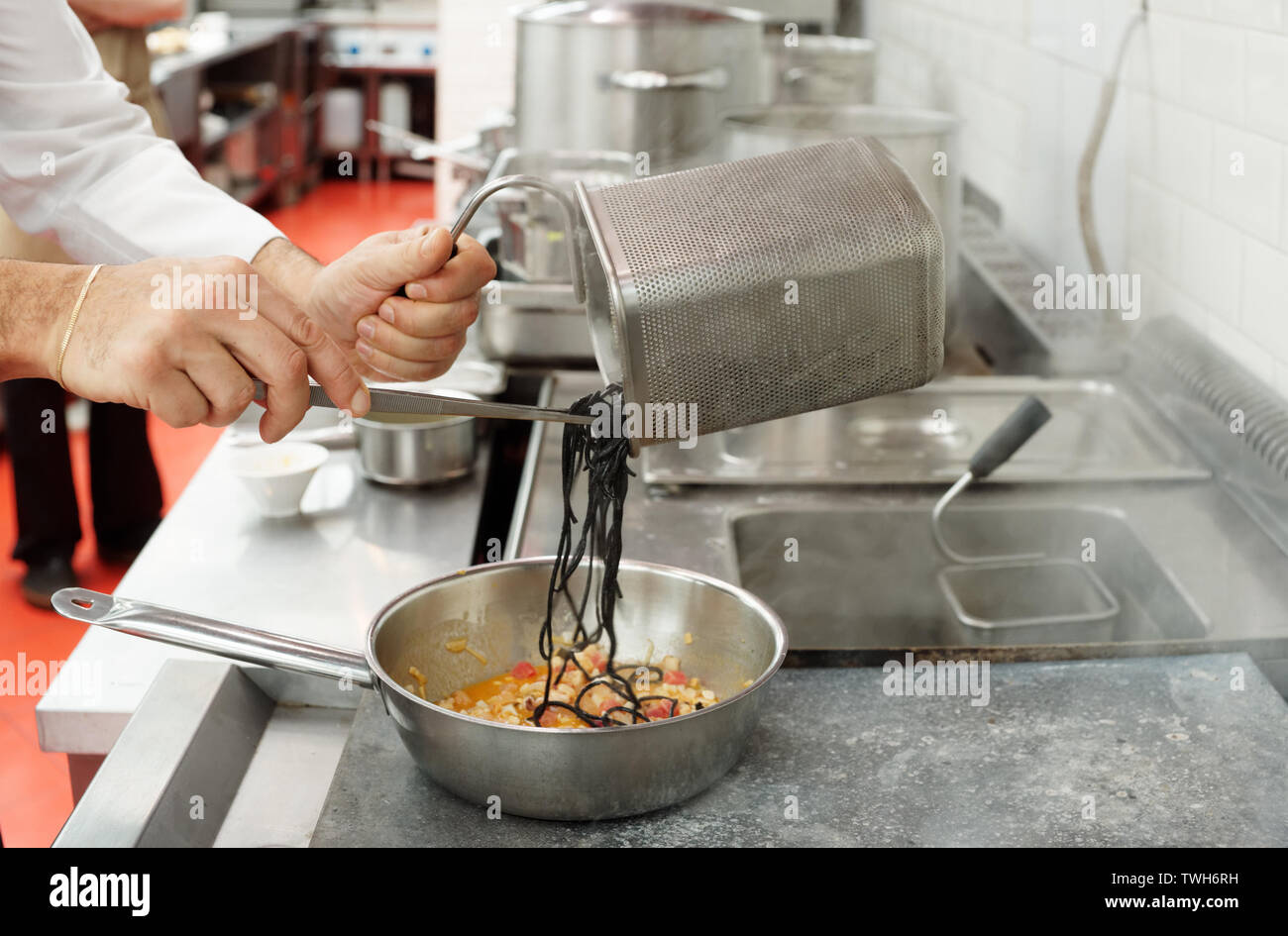 https://c8.alamy.com/comp/TWH6RH/chef-is-cooking-pasta-with-seafood-at-commercial-kitchen-TWH6RH.jpg