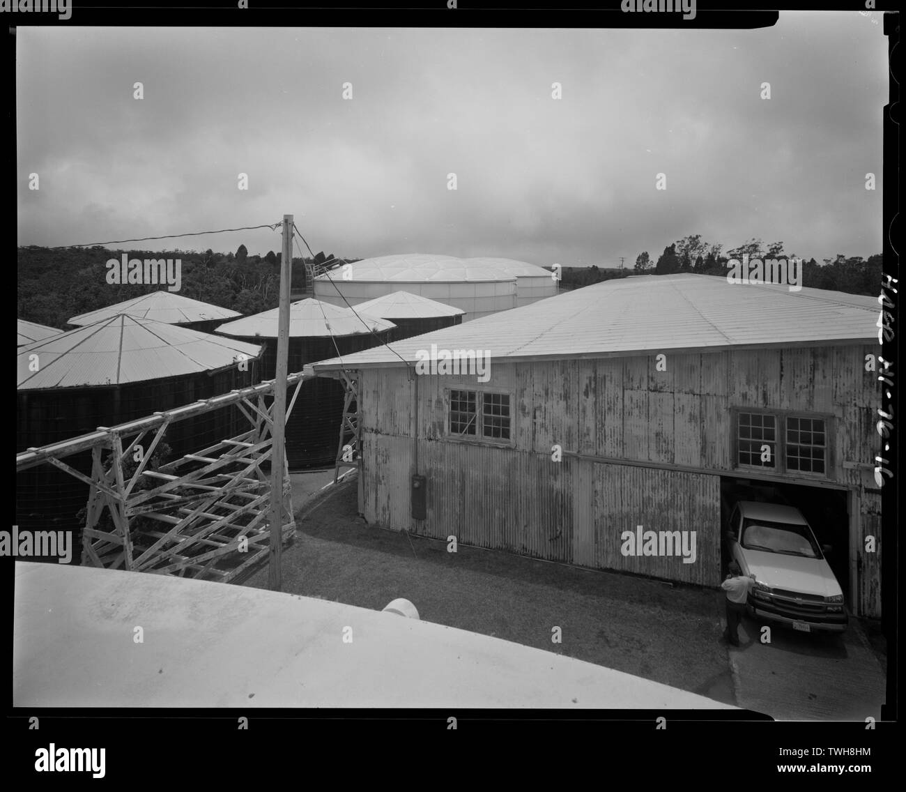 Rooftop view of old rain shed (Building No. 43), pipeline on trestle, and water tanks. Hawaii