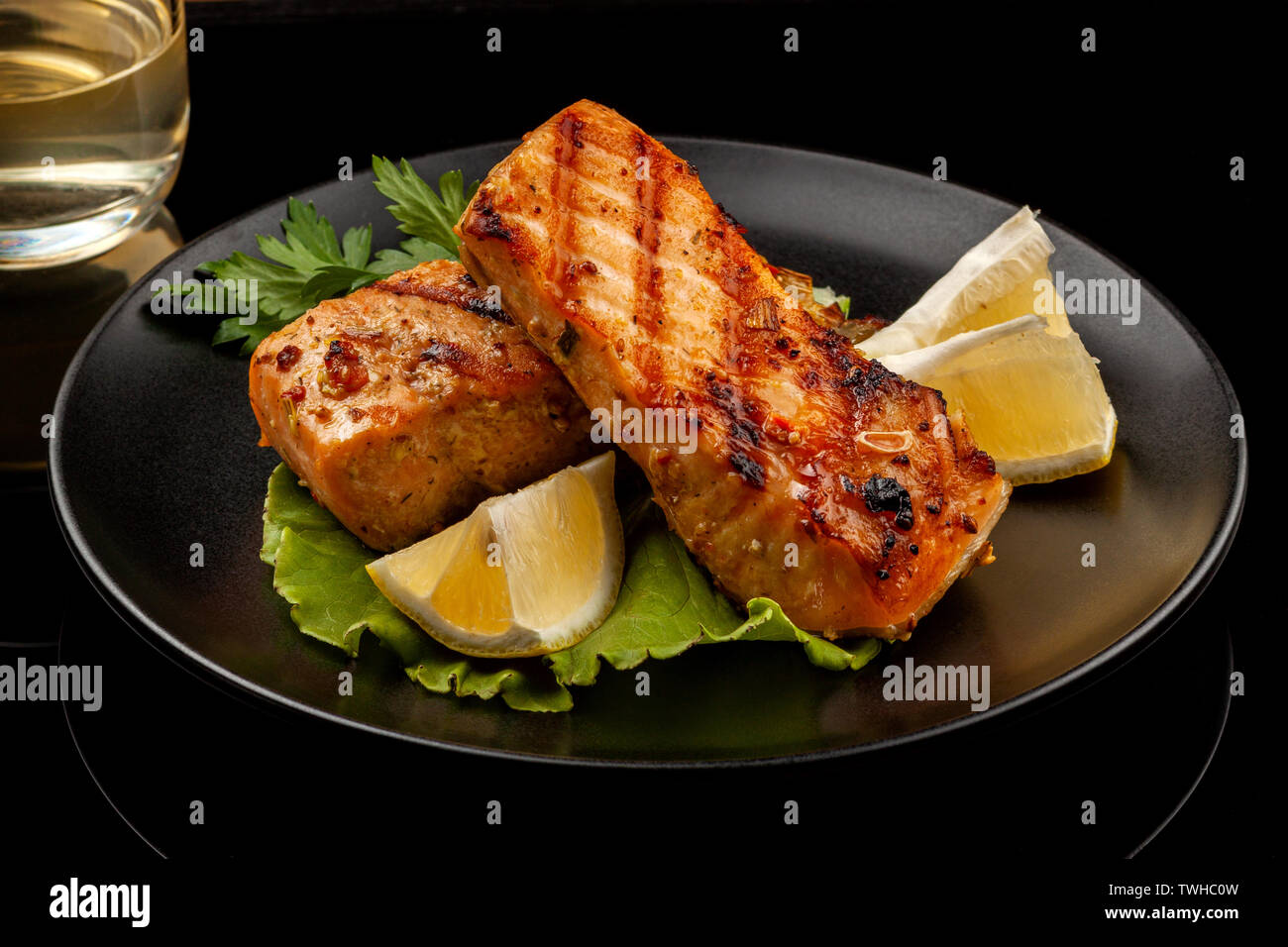 Fish, trout, chum salmon, humpback, a piece baked, grilled, with a slice of  lemon and lettuce Stock Photo - Alamy