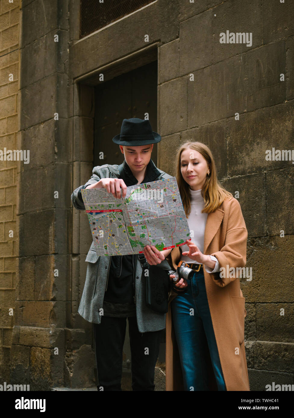 Two stylish friend standing at the street and look for something using ...