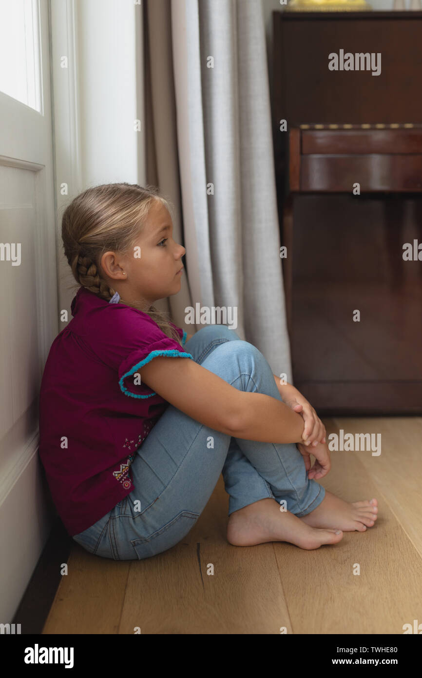 Sad girl sitting alone in corner at home Stock Photo Alamy