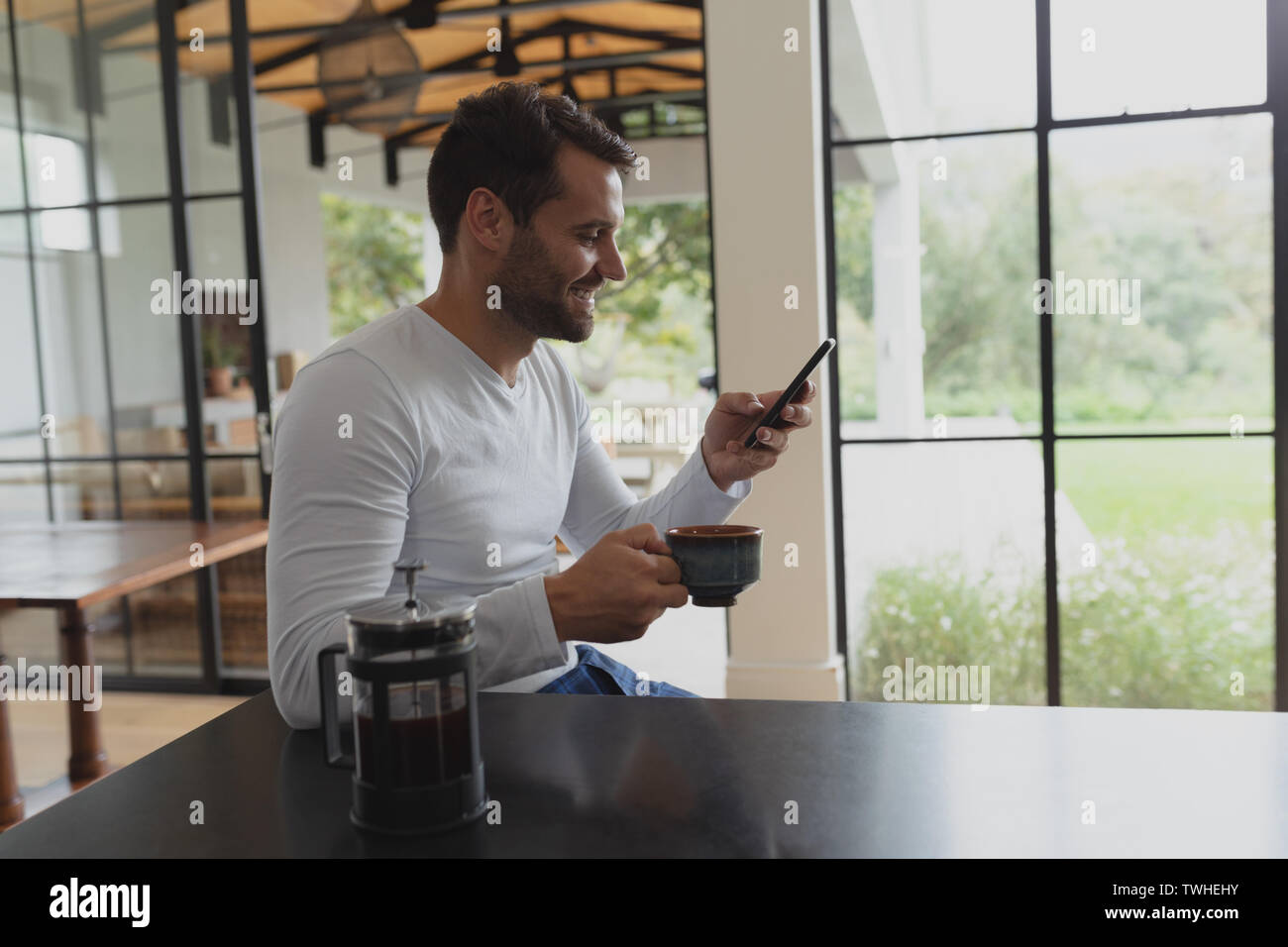 Man with coffee cup using mobile phone Stock Photo